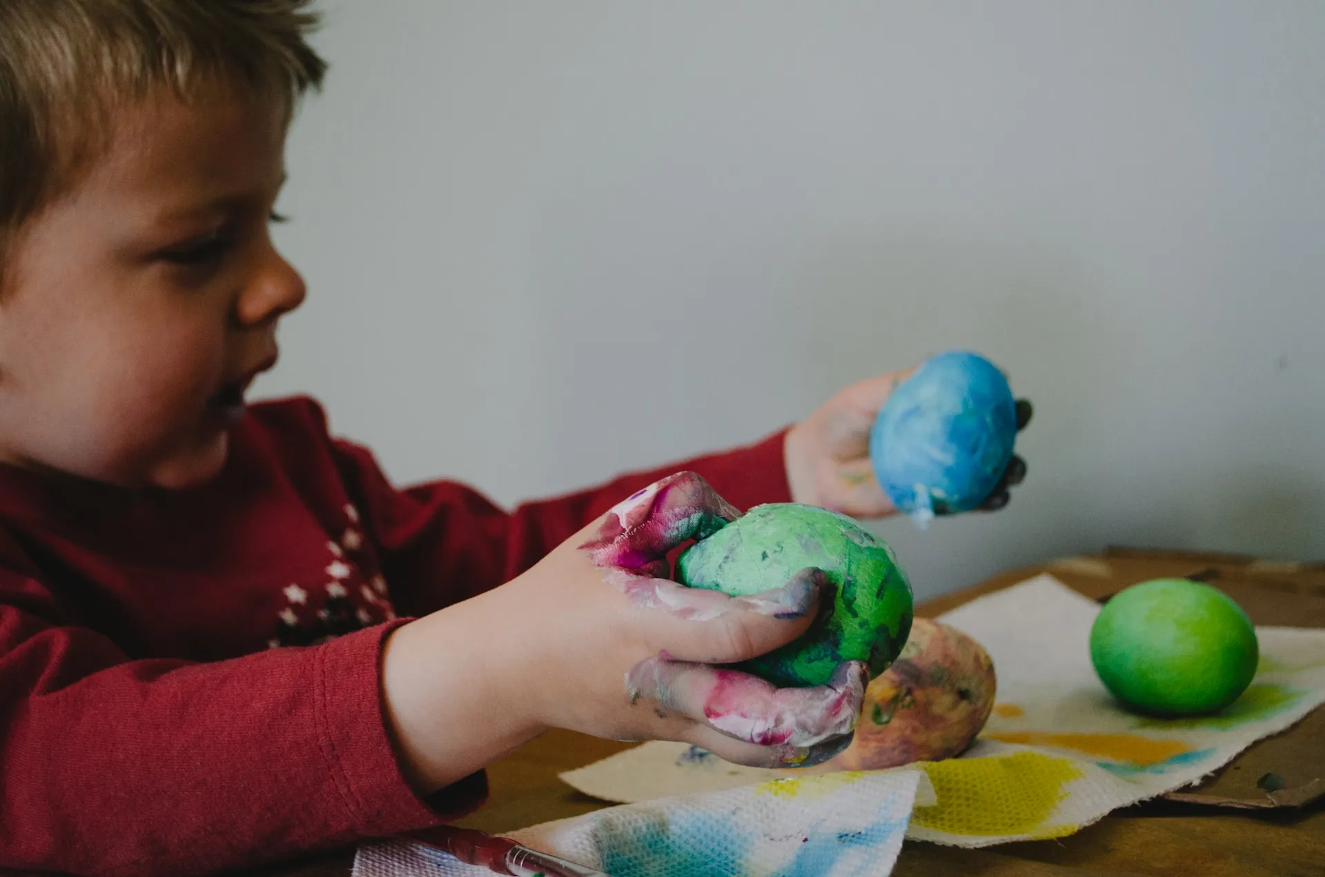 A kid painting eggs