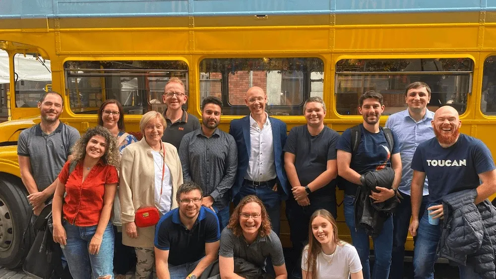 (most of) the team at fourTheorem on a day out in Dublin in front of a yellow bus
