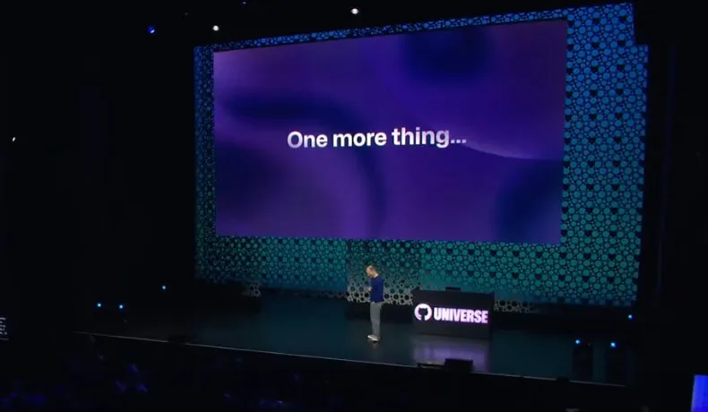 GitHub Universe 2023, Day 1, Thomas Dohmke on stage with a slide in the background saying "One more thing", mimicking the Steve Job's launch of the iPad